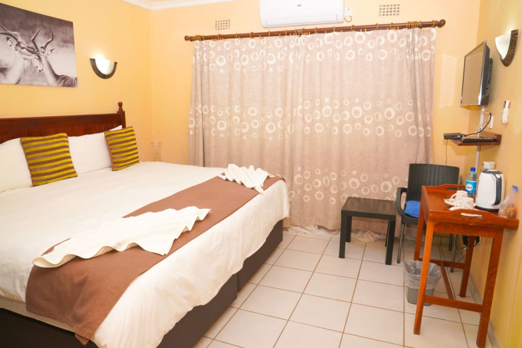 Guest room with a double bed, desk and tea station