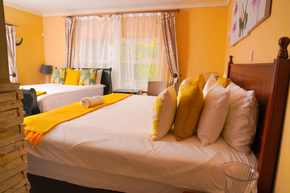 Guest room with a double bed and yellow cushions